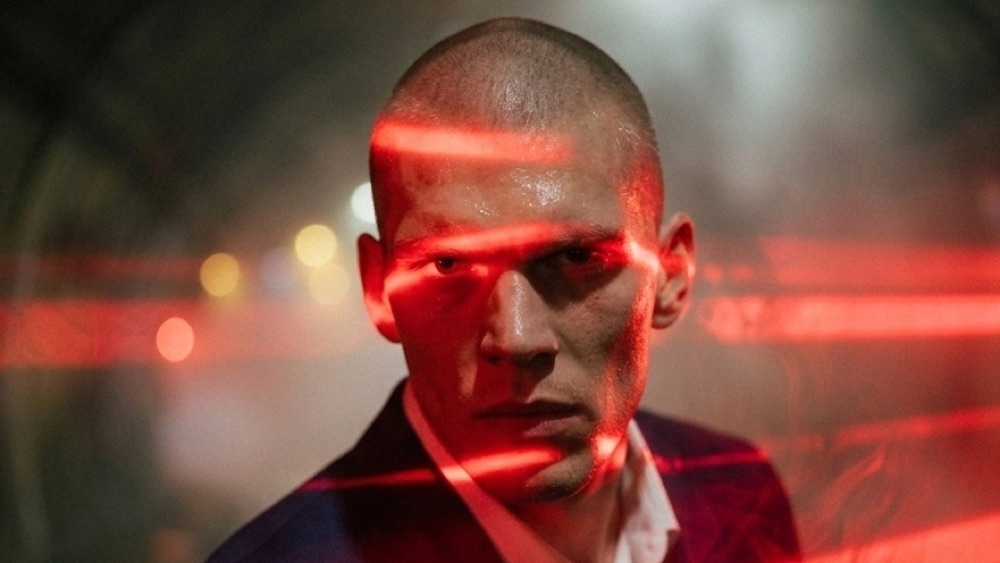 Reference still: a man's face lit by red light strips
